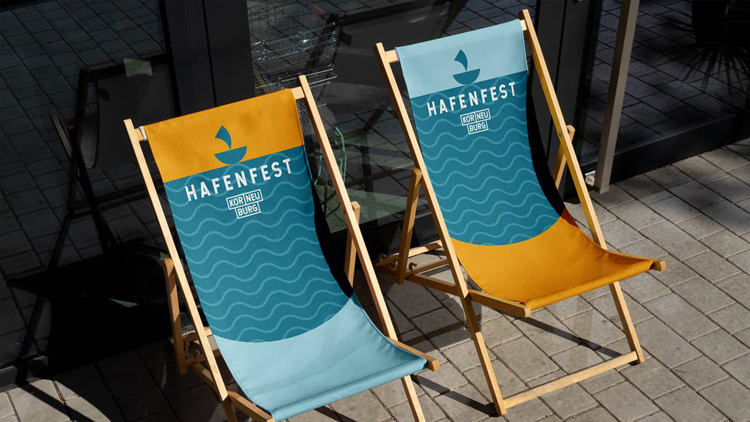 Zwei gebrandete Liegestühle mit dem Logo des Hafenfests in Korneuburg – City Events planen beginnt bei der Gestaltung von starken, wiedererkennbaren Markenmomenten im öffentlichen Raum.