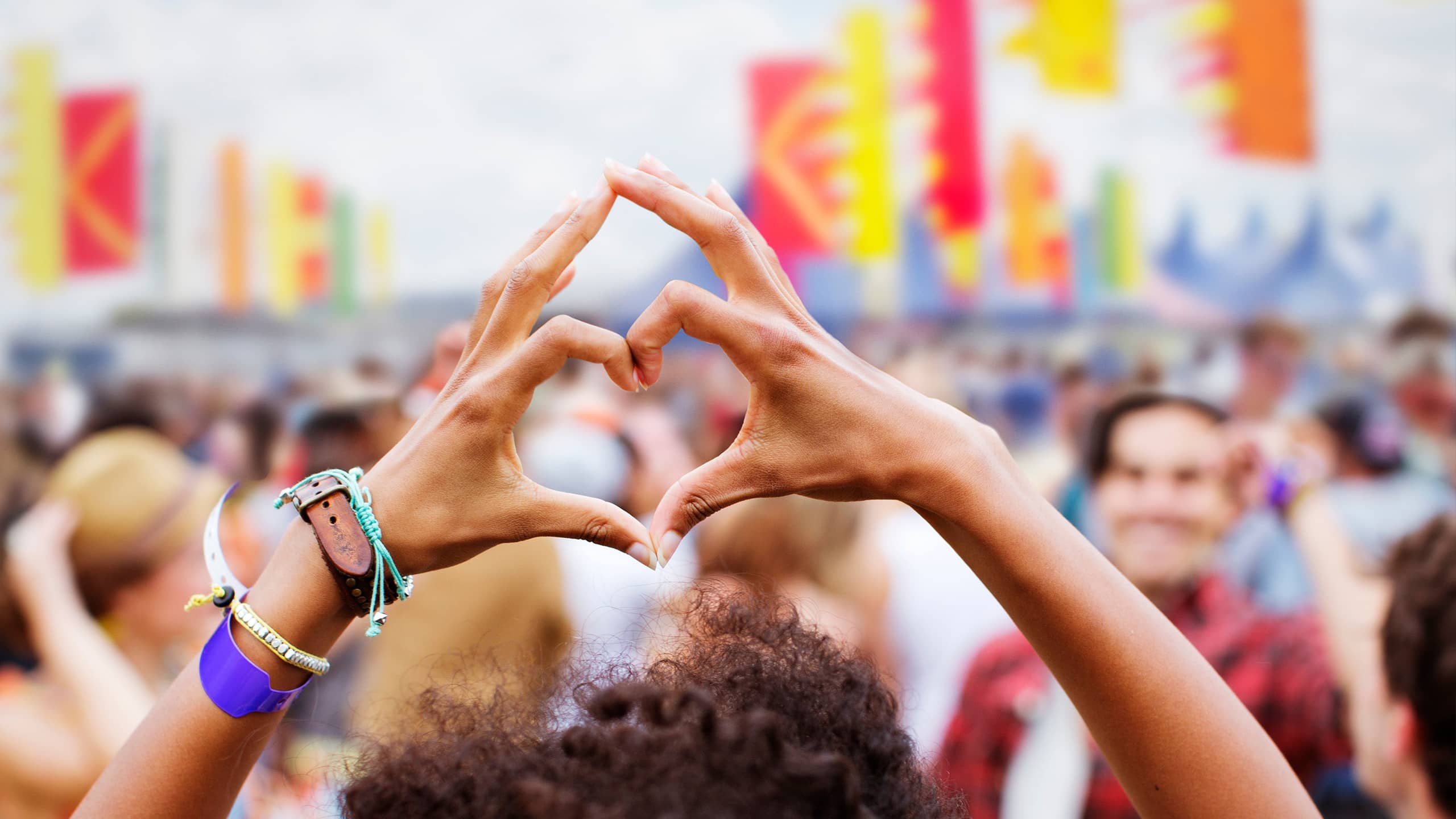 Festivalbesucher formt ein Herz mit den Händen – Symbolbild für die emotionale Verbindung einer Stadt als Love Brand.