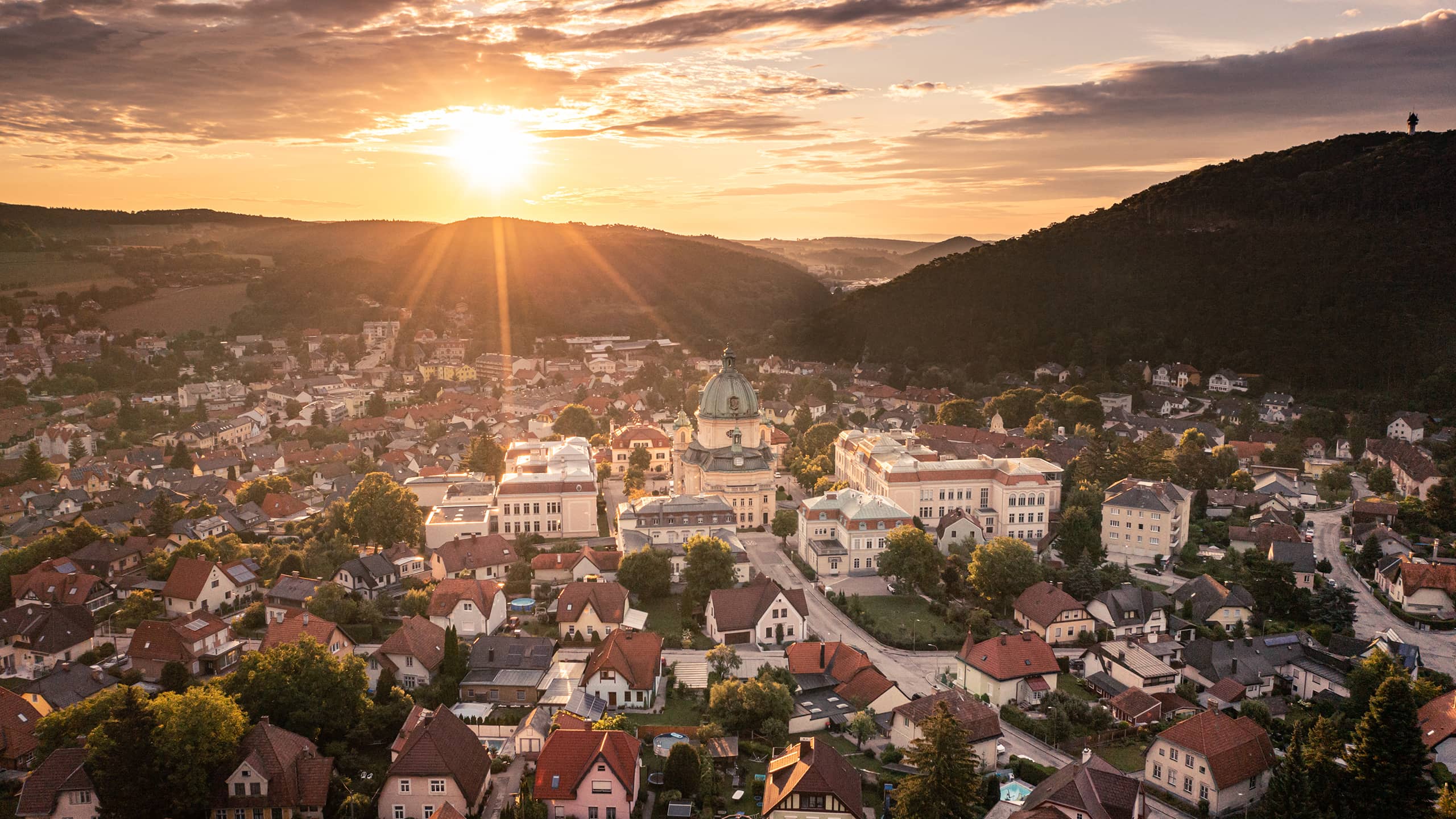 Luftaufnahme von Berndorf im Sonnenuntergang mit Blick auf die beeindruckende Margaretenkirche – Stadtpanorama im Herzen des Triestingtals.