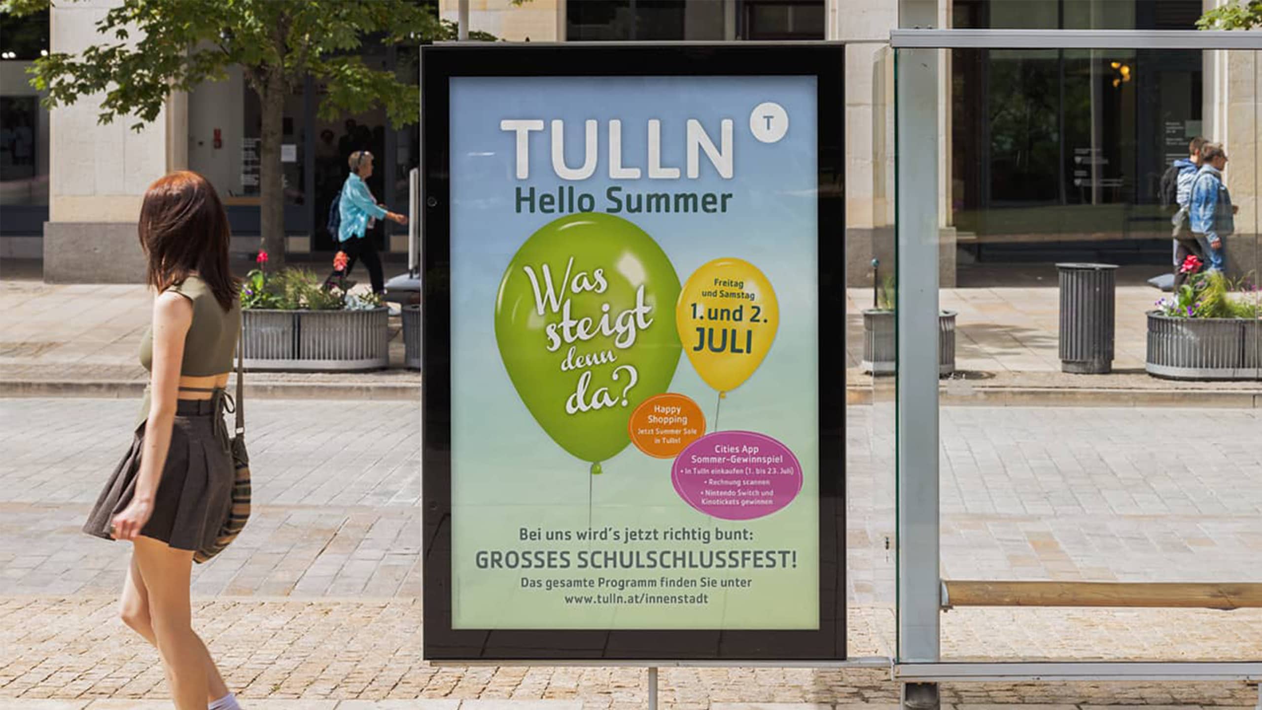 Sommersujet der Stadt Tulln mit bunten Luftballons und Schulschlussfest-Ankündigung – fröhliches Stadtmarketing mit Fokus auf Familien & Innenstadtbelebung.